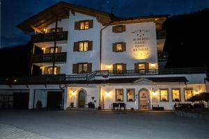 a large white building with a sign on it at night at Hotel Garnì Sant'Antonio con Spa in Madonna di Campiglio