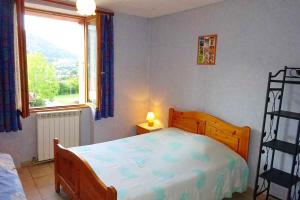 ein Schlafzimmer mit einem Bett und einem großen Fenster in der Unterkunft Maison spacieuse à Villar-Saint-Pancrace avec vue montagne in Villar-Saint-Pancrace