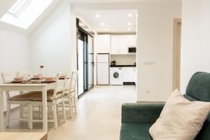 sala de estar y comedor con mesa y sillas en Apartamentos Kouohana, en Fuengirola