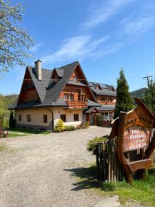 a large house with a sign in front of it at POD ROŻKAMI in Cisna