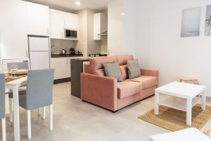 a living room with a couch and a table at Apartamentos Kouohana in Fuengirola