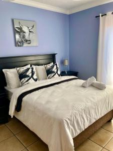 een slaapkamer met een groot bed met blauwe muren bij 37 On Eagles in Hartbeespoort