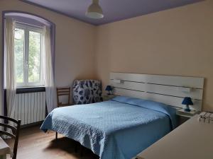 a bedroom with a bed and a chair and a window at Itaca in Varazze