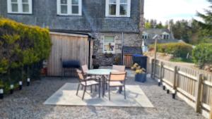 a patio with a table and chairs and a fence at Deeside Holiday Cottages in Dinnet