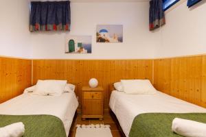 two beds in a room with wooden walls at Chalet adosado en Pasito BM13 in Pasito Blanco
