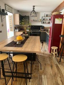 a kitchen with a large wooden table and stools at Villa de 4 chambres avec piscine privee terrasse amenagee et wifi a Omerville in Omerville