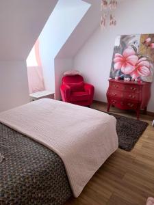 a bedroom with a bed and a red chair at Villa élégante à Omerville avec piscine privée in Omerville
