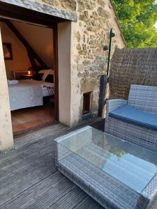 patio z kanapą i łóżkiem oraz sypialnią w obiekcie Gîtes Le clos de Veyrignac w mieście Veyrignac