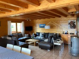 a living room with a couch and chairs and a table at CHALET REROLLE in Doucy