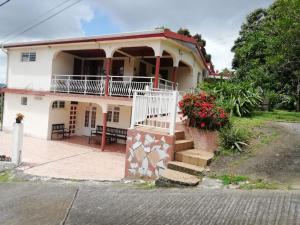 een huis met een veranda en een trap ervoor bij Villa zéto in Sainte-Marie