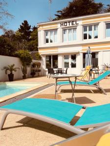 un hotel con tavolo e sedie accanto a una piscina di Hôtel Casita del Mar a Saint-Jean-de-Monts