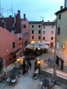 een binnenplaats met tafels, stoelen en gebouwen bij Campitelli view in Rovinj