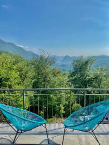 two blue chairs sitting on a balcony with a view at Casa Cristina - Stunning Lake & Mountain View in Roveredo Capriasca