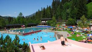 un gruppo di persone in una piscina in un resort di Chalet Finkenwiese a Zweisimmen