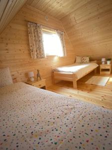 1 dormitorio con 2 camas en una cabaña de madera en Domek na Wsi, en Bodzentyn