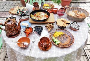 uma mesa com muitos pratos de comida em Guest House Evergreen em Margilan