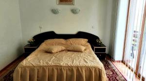 1 dormitorio con 1 cama con 2 almohadas en Pensiunea Anca, en Crisan