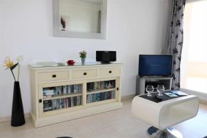 a living room with a tv and a white cabinet at Apolo17 E39 2 dormitorios in Calpe