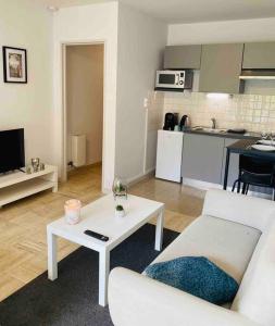 sala de estar con sofá blanco y mesa en KASA VOYTIER Parking privé & Wifi - Balcon & Ascenseur en Saint Etienne