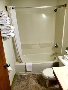 a bathroom with a tub and a toilet and a sink at Super 8 by Wyndham Ticonderoga in Ticonderoga