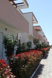 una fila de casas con flores rojas a un lado en Tea Residence, Gjiri i Lalzit Apartments en Durrës