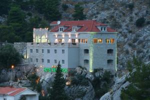 a house with a mountain range and mountains at Hotel Villa Dvor in Omiš