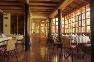 a dining room with tables and chairs and windows at IORANA HOTEL Urubamba in Urubamba +23 photos
