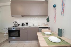 een keuken met roestvrijstalen apparatuur en een tafel met borden erop bij Antheon apartments in Vathi