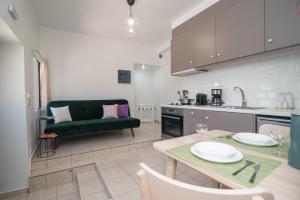 een keuken en een woonkamer met een tafel en een bank bij Antheon apartments in Vathi