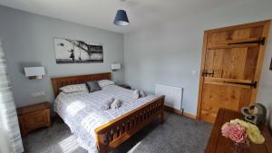a bedroom with a bed and a wooden door at Deeside Holiday Cottages in Dinnet