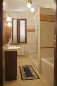 a bathroom with a sink and a tub and a toilet at Poggio Bella Vista in Castiglione del Lago