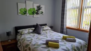 a bedroom with a bed with yellow pillows on it at Deeside Holiday Cottages in Dinnet