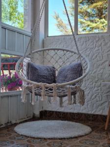 a hanging chair with two pillows on a porch at Harmony cozy home in Podgorica