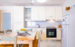 een keuken met witte kasten en een tafel met een fruitschaal bij Holidays Dream Laura - Leuca in Leuca