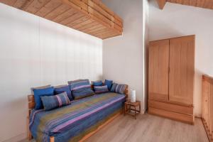 1 dormitorio con 1 cama con almohadas azules en VUE MER Vacances en famille a cinq a Arzon, en Arzon