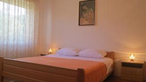 sypialnia z łóżkiem z dwiema poduszkami i oknem w obiekcie Apartment Marohnić w mieście Malinska