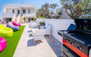 een achtertuin met een grill en een gazon met tafels en stoelen bij Holidays Dream Laura - Leuca in Leuca +27 foto's