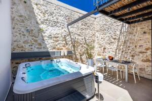 a hot tub on a patio with a table at VaSan suite in Rethymno