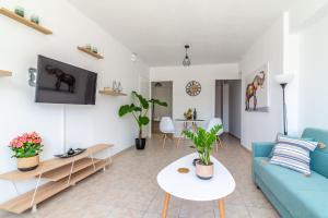 ein Wohnzimmer mit einem blauen Sofa und einem Tisch in der Unterkunft Central Apartment Next To The Beachfront in Iraklio