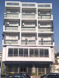 un bâtiment blanc avec des voitures garées devant lui dans l'établissement Hotel Il Dollaro, à Villa San Giovanni