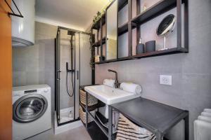 a bathroom with a sink and a washing machine at IMMOGROOM - Renovated - Loggia - Clear view - Parking common - AC - Wifi in Cannes