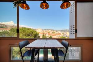 a table and chairs in front of a large window at IMMOGROOM - Renovated - Loggia - Clear view - Parking common - AC - Wifi in Cannes