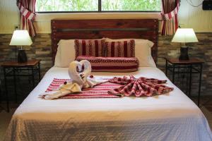 Una cama con dos cisnes y toallas. en Hortensias Chalets Vara blanca, en Heredia
