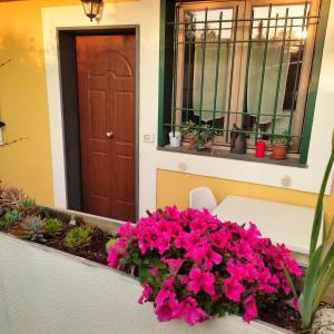 une table avec des fleurs roses devant une porte dans l'établissement Vento e Amore, à Baronissi