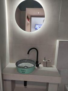 umywalką w łazience z okrągłym lustrem w obiekcie Filema w Prewezie