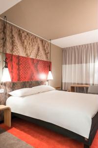 a bedroom with a large white bed in a room at ibis Bordeaux Centre - Gare Saint-Jean in Bordeaux
