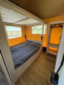 a small bedroom with a bed in a tiny house at Lodge Friesland in Grou