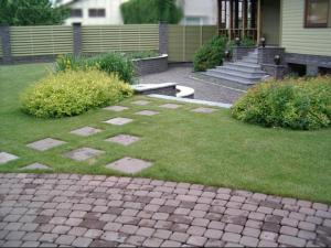 a garden with a brick walkway in front of a house at Tammehouse in Otepää