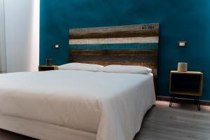 Un dormitorio con una gran cama blanca y una pared azul en Adrian's B&B, en Turi