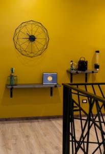 a yellow wall with shelves and a laptop on it at Adrian's B&B in Turi
